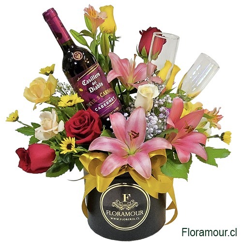 Ramo de flores mixtas en tonos cálidos presentado en una caja de regalo personalizada Acompañado de una botella de vino y dos copas para brindar
